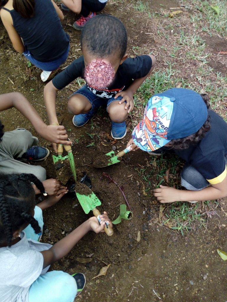 les enfants mettent la terre dans les pots